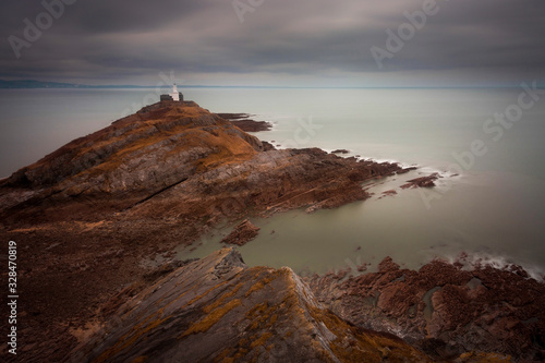 A calm sea at Mumbles lighthouse on the edge of the Gower peninsula in Swansea, Wales, UK