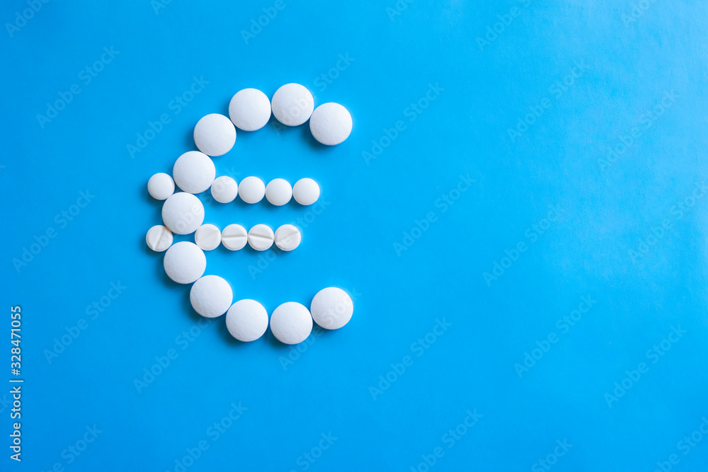 Euro sign made of round pills on blue background. Pharmacy business, medicine pill concept.