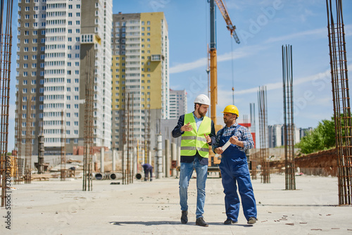 Two engineers on the construction use working equipment. © Anton