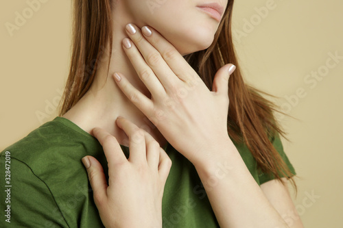 Portrait of sick caucasian woman with sore throat, cold, flu or thyroid gland problem