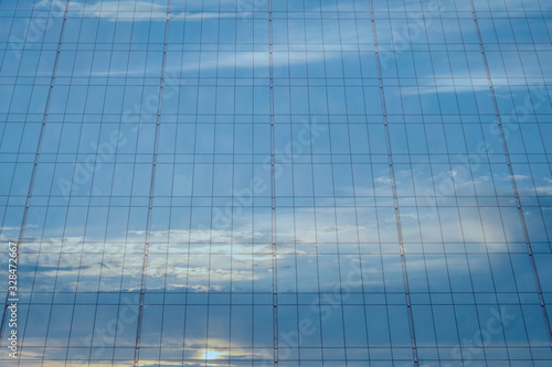 Blue glass of modern scyscraper with sky reflection.