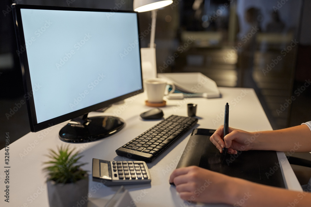 business, design and technology concept - hands of woman or graphic designer with computer and pen tablet working at night office business, design and technology concept - hands of woman or graphic designer with computer and pen tablet working at night office