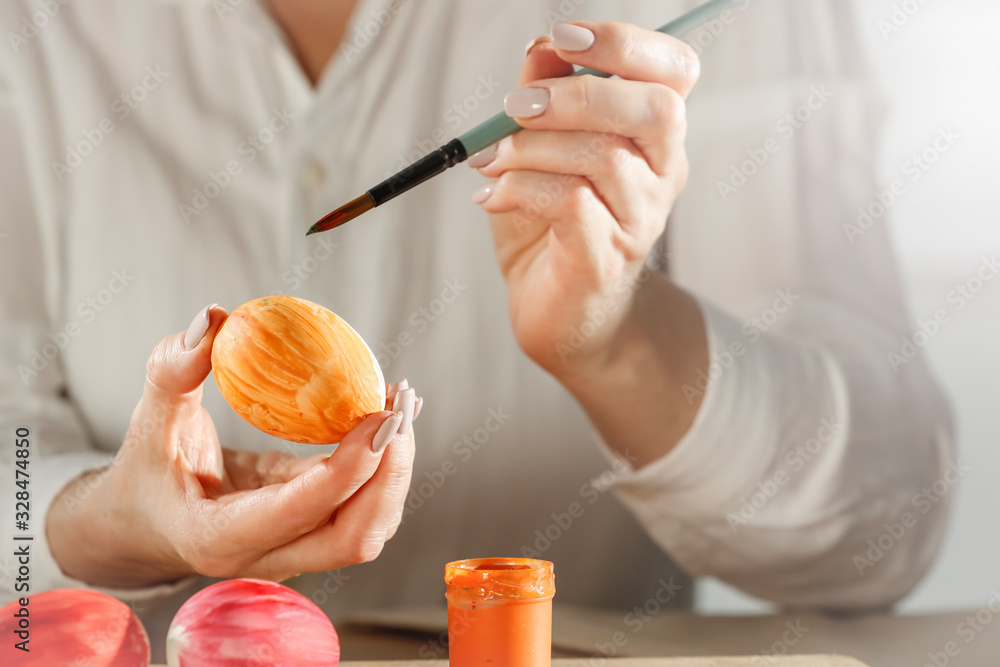 Hands painting Easter eggs on wooden table on a spring day Hands painting Easter eggs on wooden table on a spring day