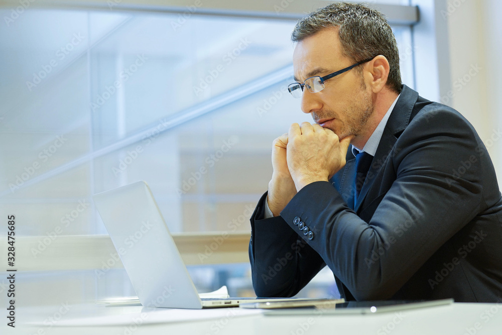 Obraz premium Businessman at work being thoughtful in front of laptop