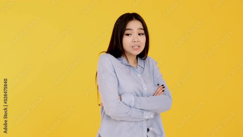 girl on yellow background shrugging his shoulders. emotions, doubt , hesitation girl on yellow background shrugging his shoulders. emotions, doubt , hesitation