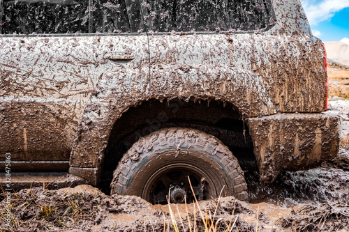 Adventure travel concept background. 4x4 off-road suv car stuck in mud. Adventure travel concept background. Offroad car.