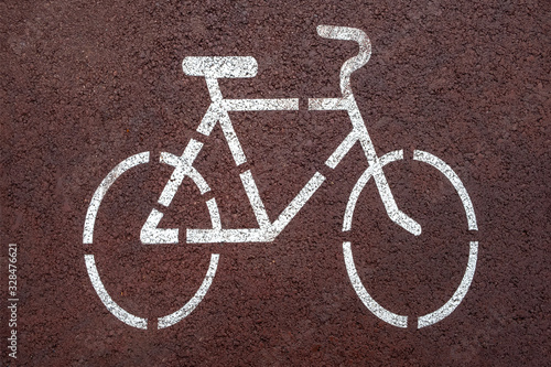 Cycle lane sign drawn in white on red cycle lane.