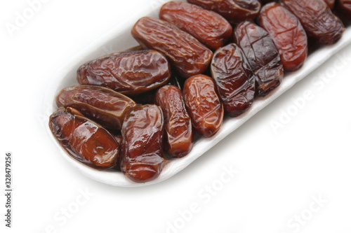 Wallpaper Mural Dried dates ina plastic bowl isolated on white background. Date fruits on white Torontodigital.ca
