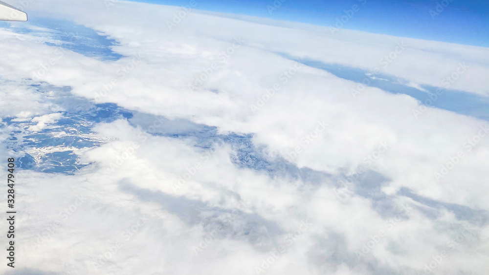 Aerial view. White clouds in the blue sky. View of beautiful clouds from an airplane window. Aerial view. White clouds in the blue sky. View of beautiful clouds from an airplane window.