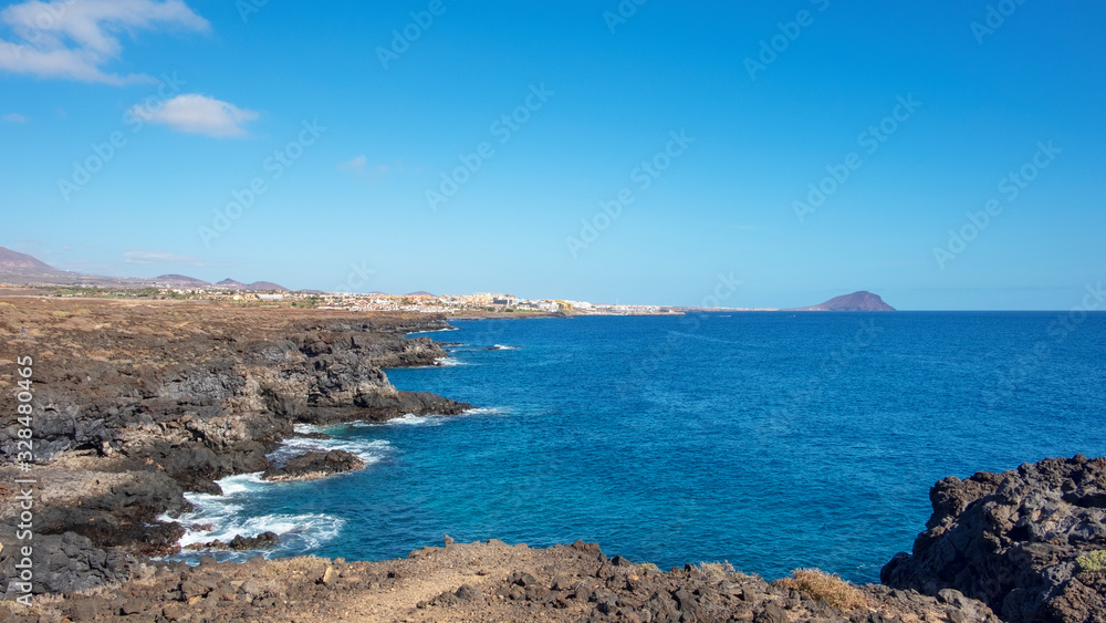 Rough and rocky landscape of the coastal walking path from Montana Amarilla to Amarilla Golf and Golf Del Sur with views of the small fishing villages and Montana Roja, Tenerife, Canary Islands, Spain