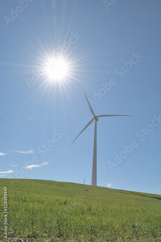 Wind turbine a sunny day with the sun shining and the blue sky photo