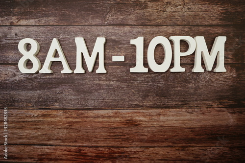 Opening Times 8 am to 10 pm letter on wooden background