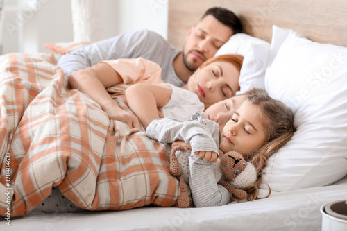 Happy family sleeping in be...