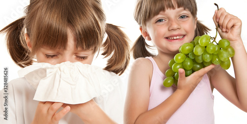  ill little girl with handkerchief and girl with fruit photo