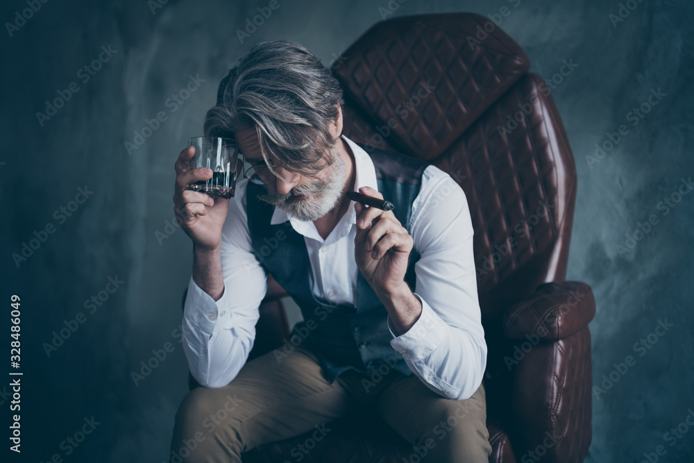 Portrait of sad old man company owner sit chair hold cigar glass cognac suffer startup fail bad hangover wear white shirt grey vest brown pants trousers isolated concrete wall background - obrazy, fototapety, plakaty 