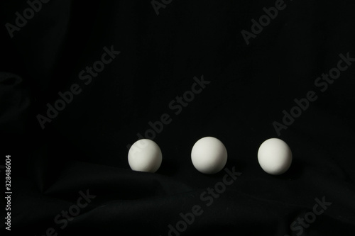 three white chicken eggs on a black background © Татьяна Лобас