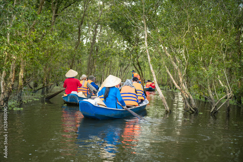 Tourism rowing boat in cajuput forest in floating water season in Mekong delta, Vietnam
