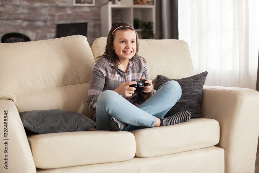 Focused little girl with braces playing video games Focused little girl with braces playing video games