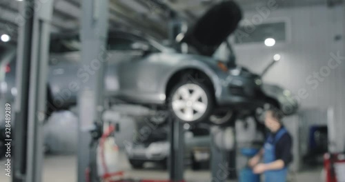 Blurred Background. Auto Mechanic Working On Car. Dealer Service Center