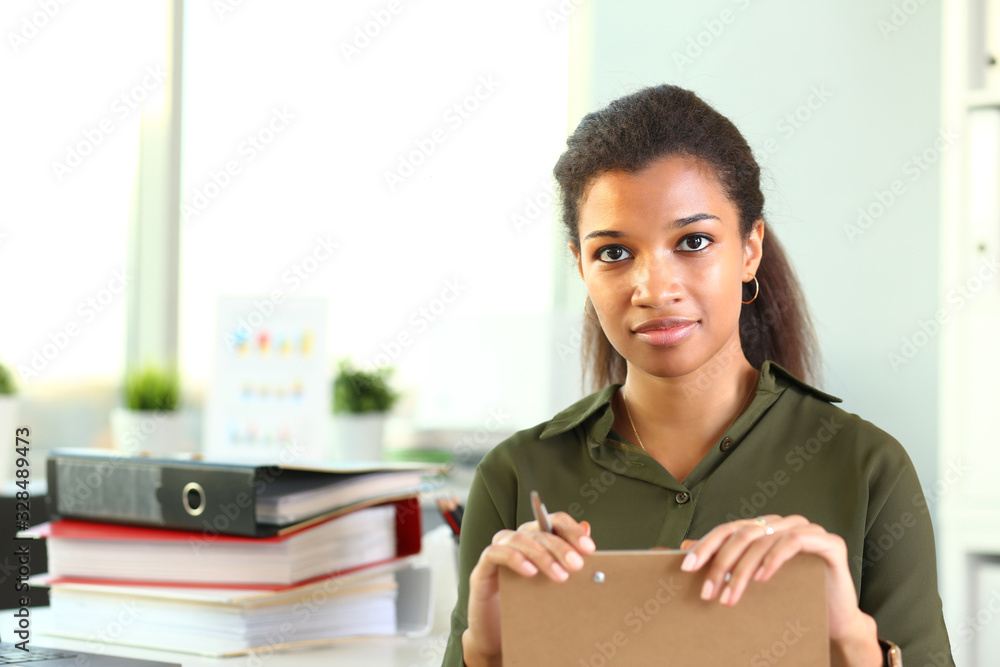 Beautiful black smiling businesswoman portrait at workplace look in camera. White collar worker at workspace exchange market job offer certified public accountant internal revenue officer concept Beautiful black smiling businesswoman portrait at workplace look in camera. White collar worker at workspace exchange market job offer certified public accountant internal revenue officer concept