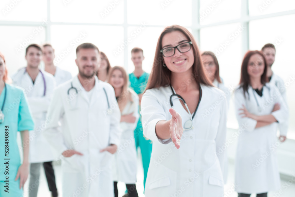 friendly female doctor holding out her hand for a handshake. friendly female doctor holding out her hand for a handshake.