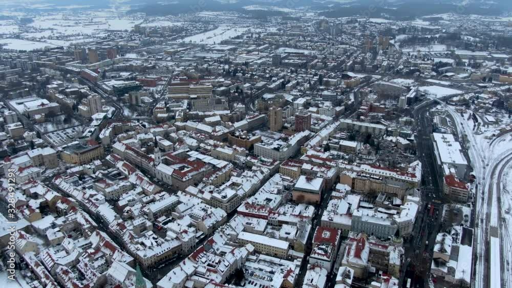 Establishing aerial drone clip of the snowy town of Celje in Slovenia during winter time Establishing aerial drone clip of the snowy town of Celje in Slovenia during winter time