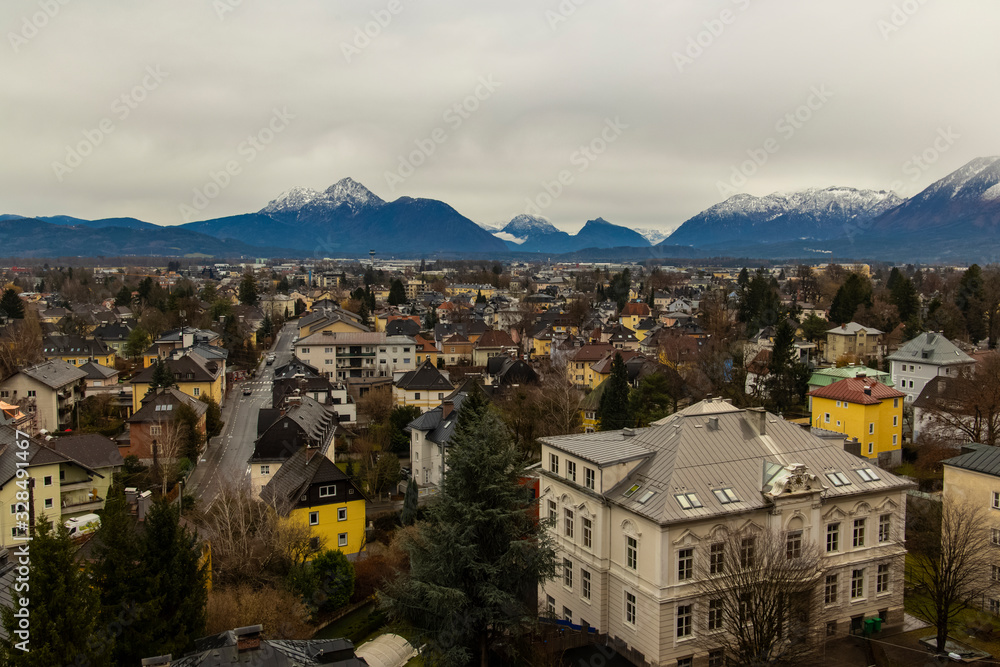 rustic moody town urban view from above depressive gray colors cloudy weather time living buildings foreground and Alps mountains background