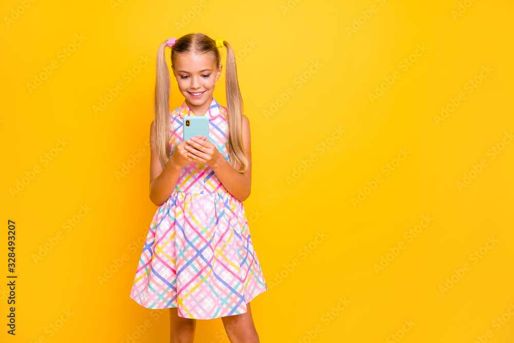 Photo of beautiful small lady hold telephone young influencer write new post for own popular modern blog wear checkered sun dress isolated bright yellow color background Photo of beautiful small lady hold telephone young influencer write new post for own popular modern blog wear checkered sun dress isolated bright yellow color background