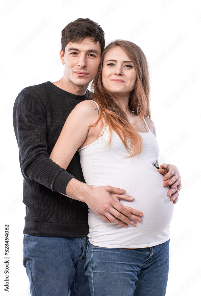 Happy smiling couple in love expecting child posing in studio Happy smiling couple in love expecting child posing in studio