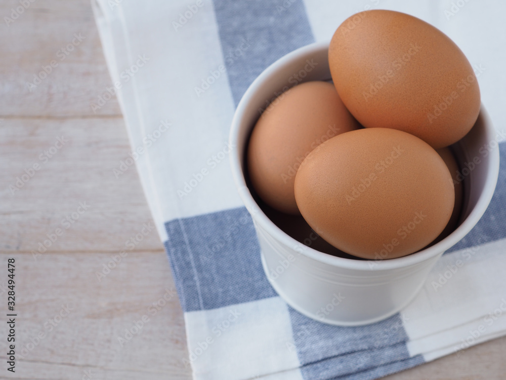Fresh organic eggs in white bucket on wooden background. High in protein with copy space, view above. Fresh organic eggs in white bucket on wooden background. High in protein with copy space, view above.