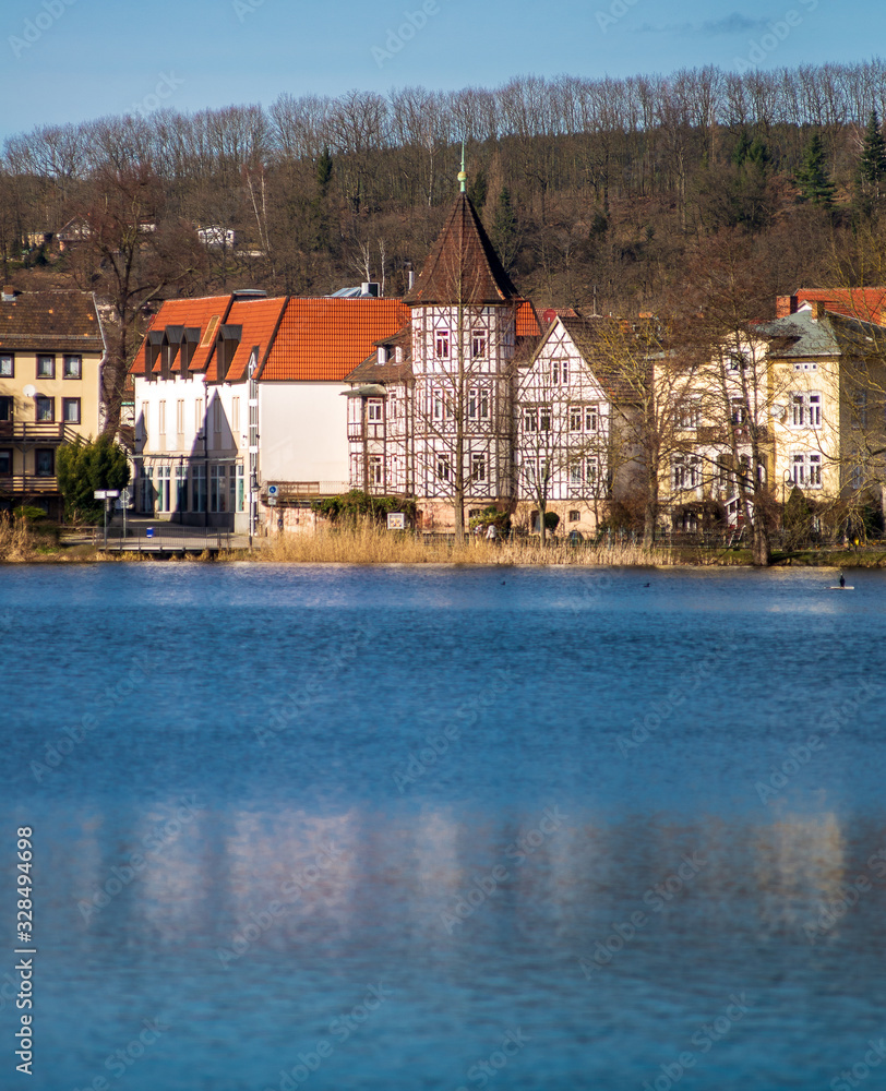 Naklejka premium Scenic view of houses by a lake with a half timbered house standing in the middle