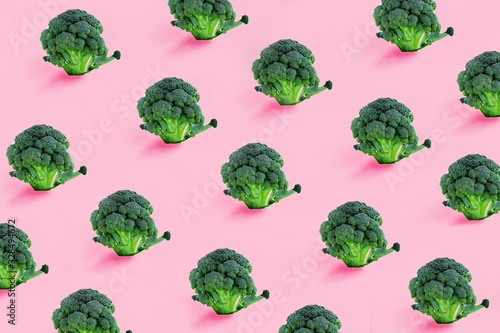 Fototapeta Broccoli on a pink background. Seamless minimalistic isometric pattern, photo collage, vegan pop art design, vegetable backdrop. Postcard, print on fabric, wrapping paper.
