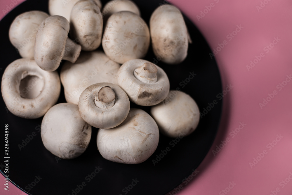 Porcini mushrooms in a black plate on a colored background