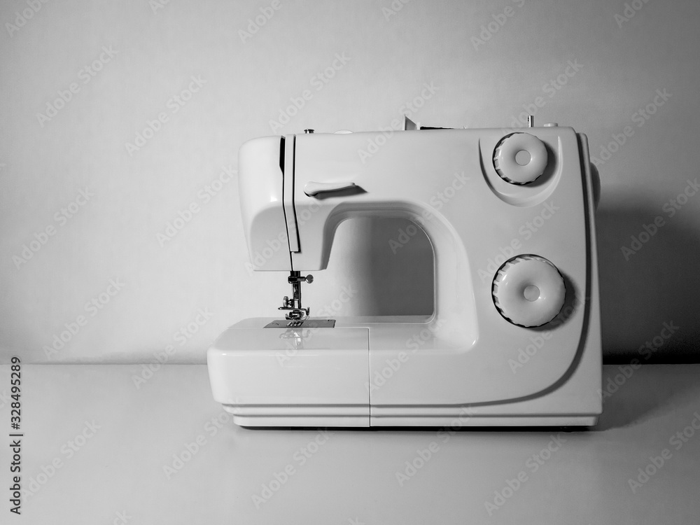 Blank sewing machine on a white table and a white wall background