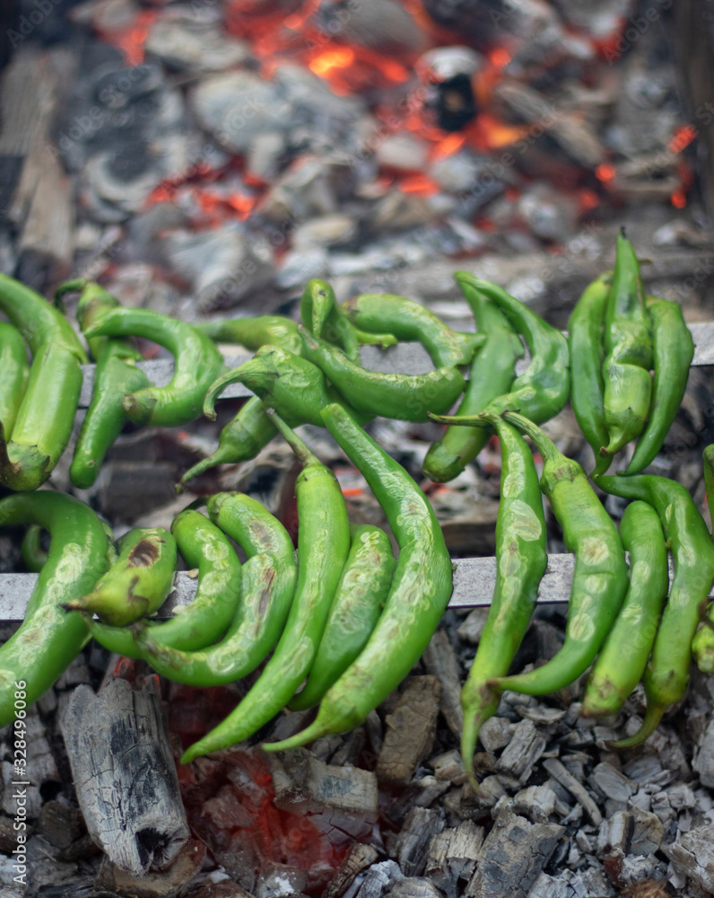 Green peppers with bottles on the grill. The embers grilled in charcoal under it is very hot. Closeup. Green peppers with bottles on the grill. The embers grilled in charcoal under it is very hot. Closeup.