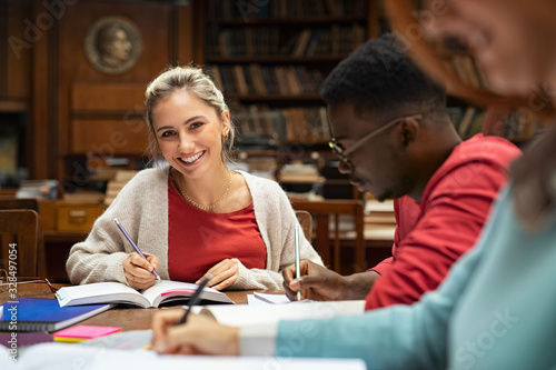 Happy smiling girl studying in university library