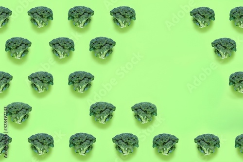 Seamless minimalistic pattern with broccoli on a green background. Photo collage, vegan pop art design, vegetable backdrop, diet, healthy food. Top view with copy space for text.