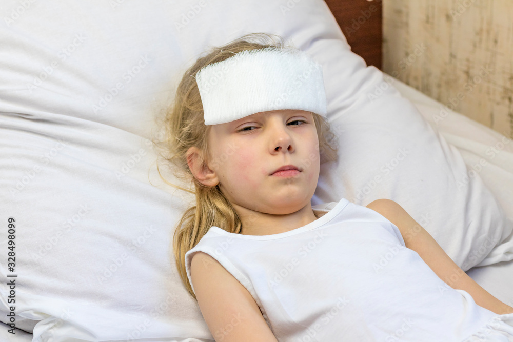 A girl with white hair lies in bed. She has a bandage on her forehead to relieve pain. Close-up. There is a tint A girl with white hair lies in bed. She has a bandage on her forehead to relieve pain. Close-up. There is a tint