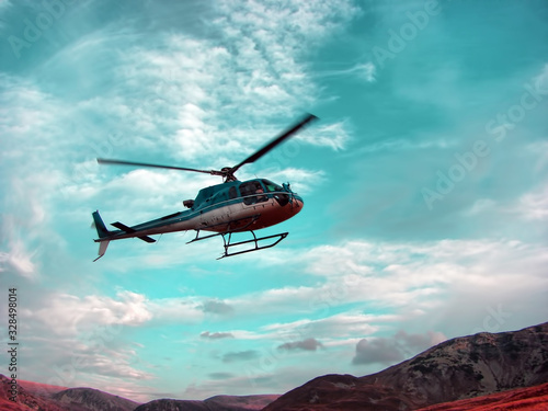 Helicopter color turquoise above the mountain