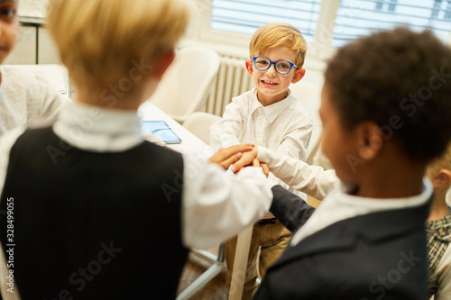 Children as a business team while hands stacking