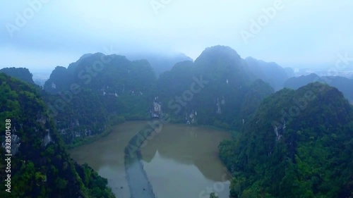 Wallpaper Mural Cinematic drone footage of majestic limestone peaks in misty and foggy weather. Ricefields in wild jungle in the spring with boat tour canal in Tam Coc, Ninh Binh, Vietnam Torontodigital.ca