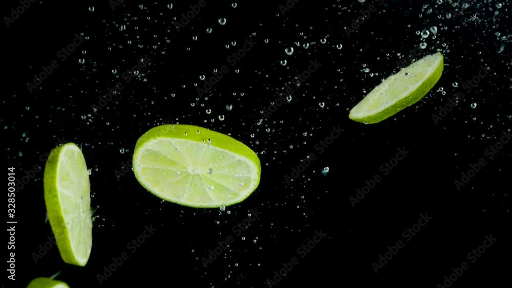 green lemon splashing into water- slow motion
