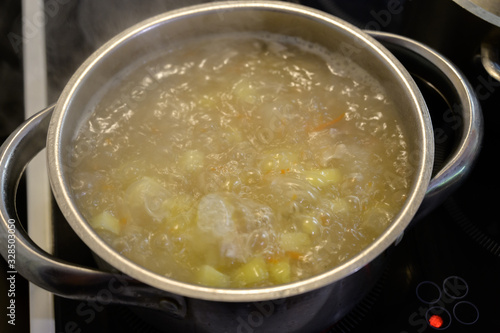 Chicken soup with potato and cabbage in the pan. Slow shutter speed.