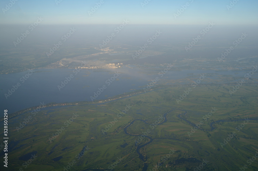 View from the plane window to the clouds and the earth