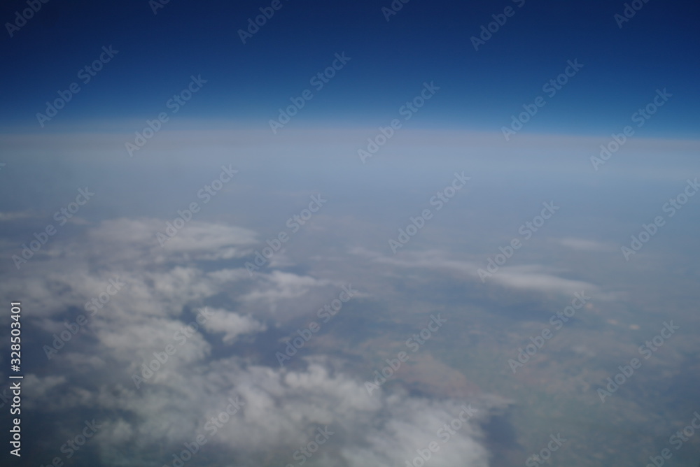 View from the plane window to the clouds and the earth