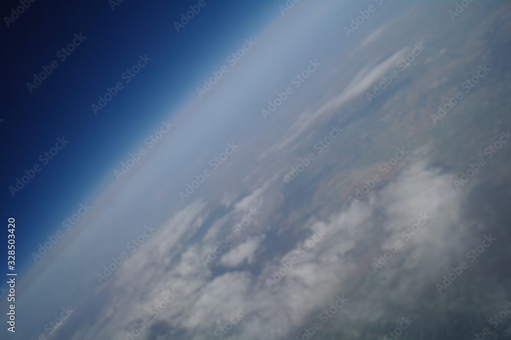 View from the plane window to the clouds and the earth