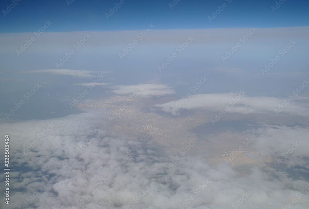 View from the plane window to the clouds and the earth
