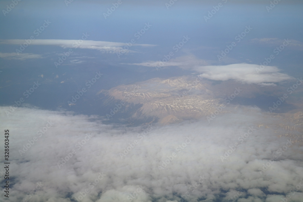 View from the plane window to the clouds and the earth