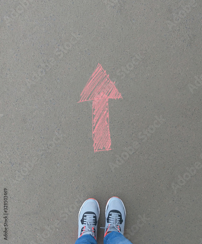 woman shoes on asphalt and opposing direction arrows on asphalt ground, personal perspective footsie concept for finding your own way photo