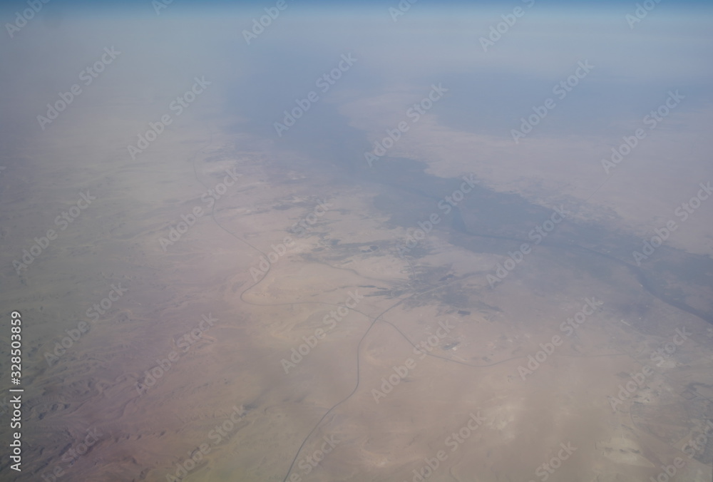 View from the plane window to the clouds and the earth